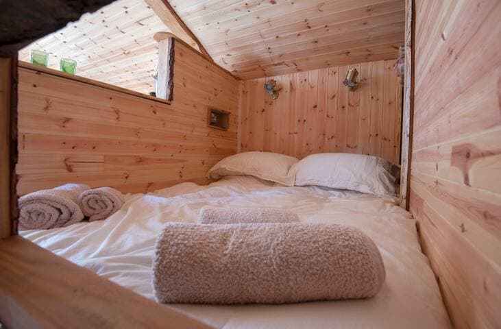 Cosy sleeping area with double bed in Clanranald. Unlike the other 2 Bothies, Clanranald only sleeps up to 3 guests - 2 in a double bed and one older child/teen/small adult in the fun and quirky 'bothy platform', accessed from the double bed