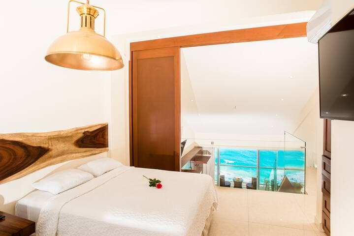 Upstairs bedroom with view of the ocean with the sliding doors open. View of the lagoon on the other side of the room. Doors slide closed for privacy.