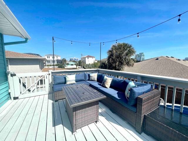 Comfortable outdoor deck has a gas grill and gas firepit coffee table.