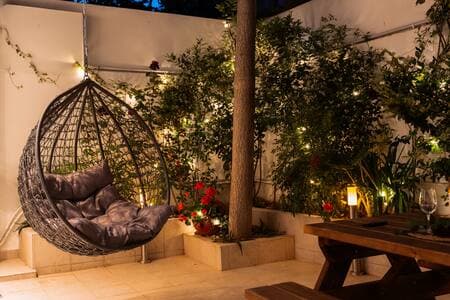 Your suite opens onto a private garden patio—it’s all yours. The rooftop terrace (same beige umbrellas, different level) is a shared space two floors up.