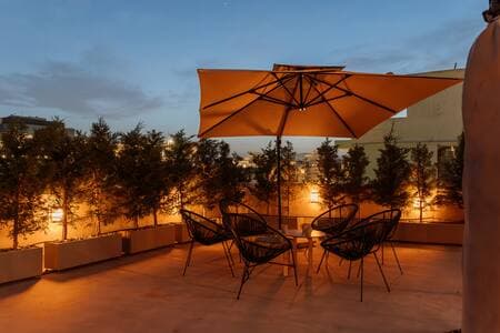 Shared rooftop gym on the 4th floor—(same umbrellas), open to all guests.
Your private garden waits just outside your suite downstairs.