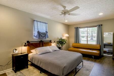 Bedroom #4 with a plush queen mattress, full length mirror, leather headboard and futon, bunk beds, and smart tv