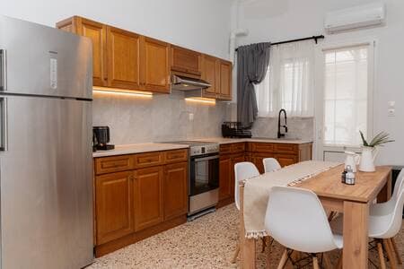 A kitchen with dining area, fully equipped with a large refrigerator and espresso machine – designed to meet all your daily needs for meals, drinks, and comfort.