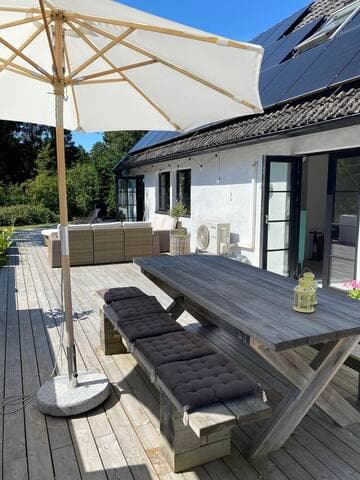 Uteplats åt söder med morgonsol . Bord och bänkar med plats för 10-12 personer