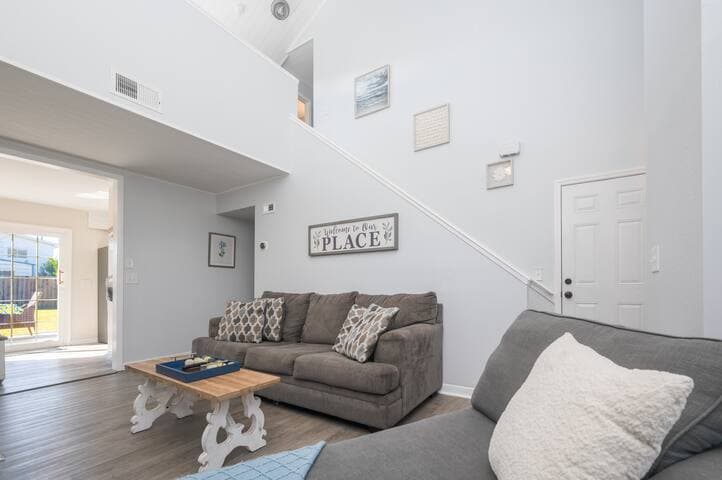 Spacious and airy living area with high ceilings, large windows, pull out couch and charming decor. The open layout provides easy access to the backyard and dining area.