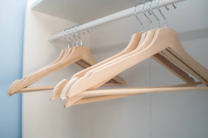 Twin bedroom with two single beds with individual bedside units, 4-way power adaptors with USB chargers and clothes storage with wooden hangers and drawers. A shelf contains a selection of mini board games.