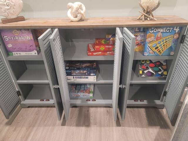 Games and puzzles in credenza cabinet for family fun.