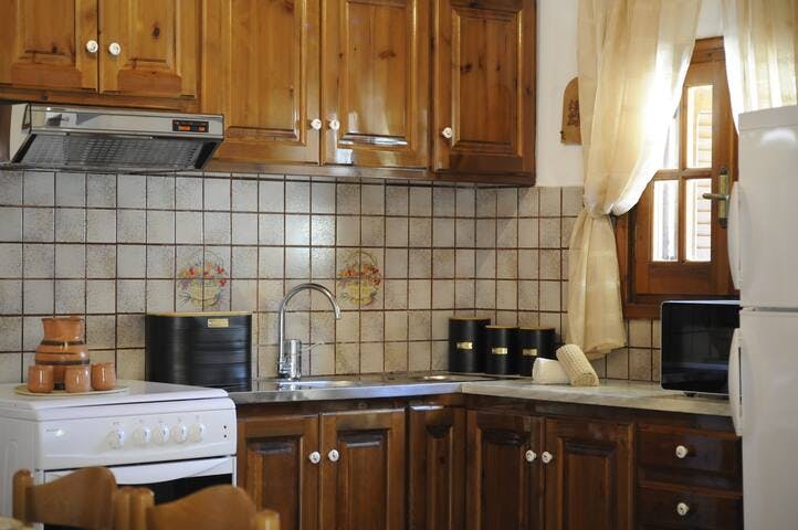 Fully equipped kitchen featuring a full size fridge, oven, microwave, kettle, coffee percolator, and utensils