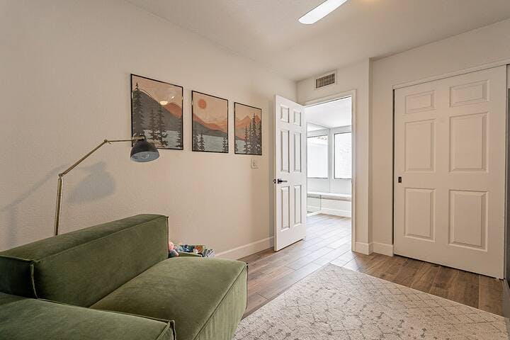 Bedroom 3 includes a cozy reading nook with a lamp and a basket of toys for entertainment. Inside the closet, you'll find a pack n play, children's swim toys and floats, and other family-friendly amenities to ensure a pleasant stay.