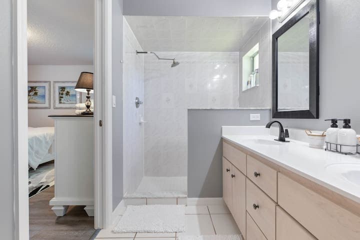 Master bathroom with double sink vanity and walk in shower. New faucets and mirrors complete the look.