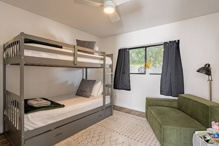 Bedroom 3 is furnished with a triple twin bunk bed, featuring a pull-out trundle for space efficiency, along with kids' toys, a pack 'n play, and pool floaties stored in the closet.