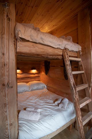 Rustic ladder to the top doubled bed which has views out from the top triangular window over the woodland