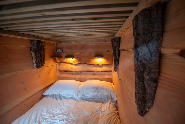 Cosy double bed with Nour Luxury bedding and salvaged maritime lights