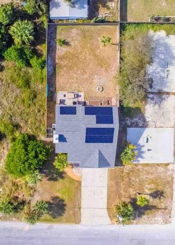 Your beach getaway with solar panels, a large fenced-in backyard, palm trees and patio.