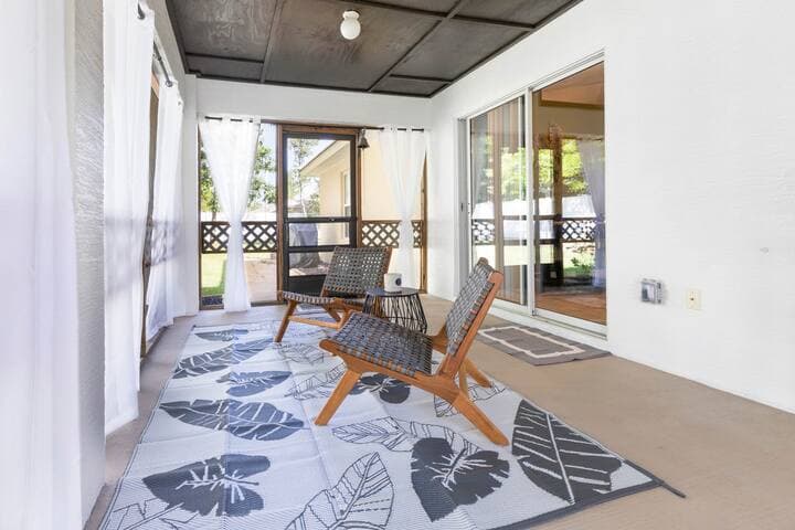 View of the lanai with chairs for enjoying your morning coffee. You will hear all the frogs, birds and bugs while you sit here. You will most likely see several little lizards as well, so be sure to keep the doors closed!