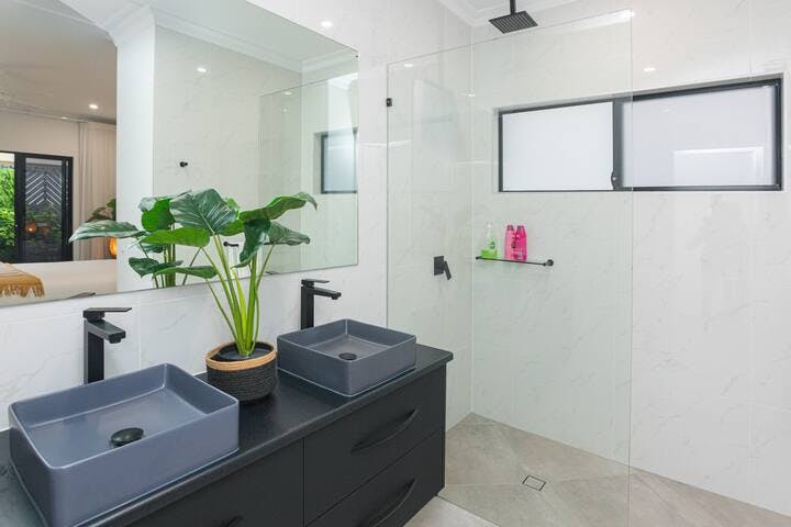 Our bathrooms are beautifully designed, featuring floor to ceiling tiling, rain showerheads and supplied with shampoo, conditioner and body wash. This ensuite has an adjoining private toilet.