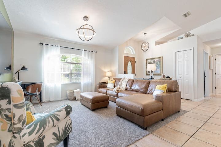 Living room with plenty of seating on the extra large, comfy leather couch. New light fixtures provide the perfect balance.