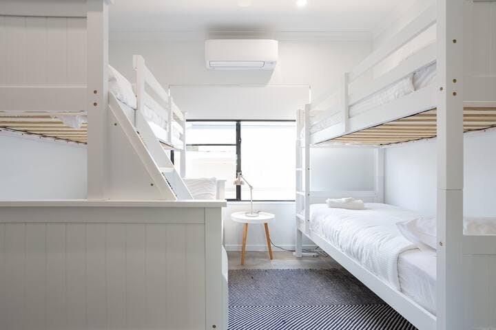 The bunk room is a very flexible sleeping space. On one side we have a double bed on the bottom, which is comfortable and can sleep up 2 adults, above and opposite are 3 single beds. So this room is capable of sleeping, 5 people.