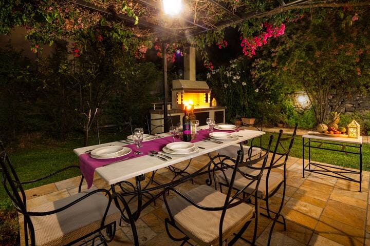 "Al fresco" dining area at night and the BBQ in the background.