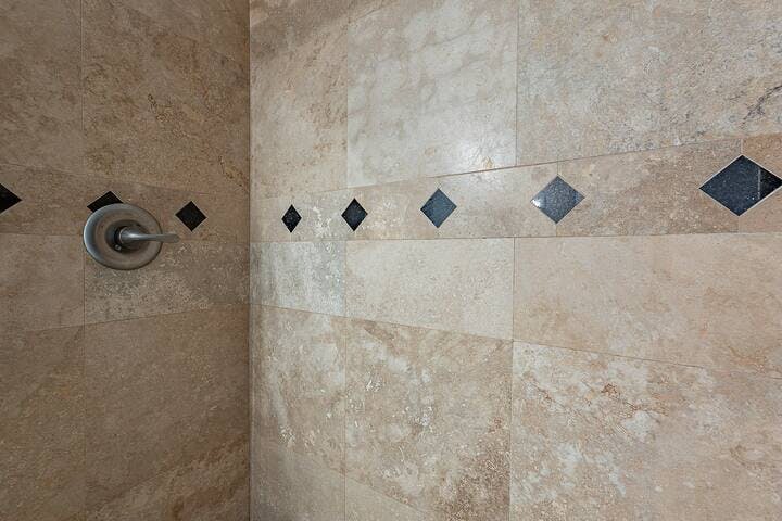 Bathroom 2 boasts a beautifully tiled shower, adding a touch of elegance and sophistication to the space. With its meticulous tile work, the shower provides a luxurious and relaxing experience for guests.