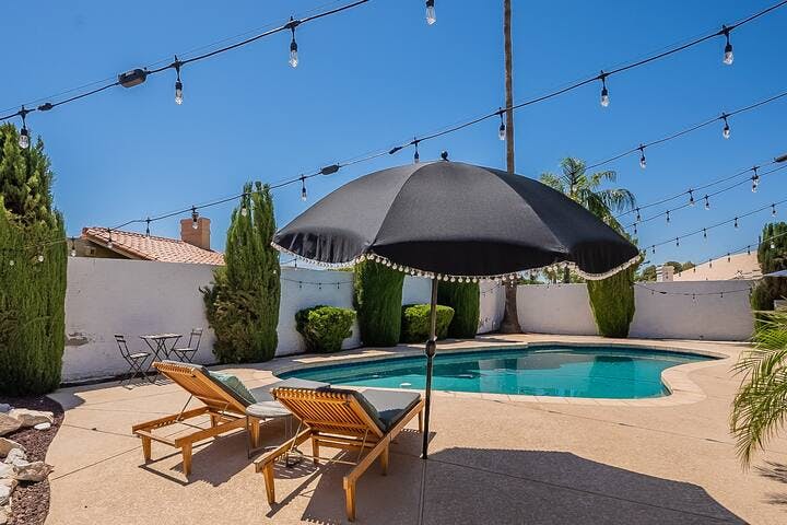 Relax and unwind by the pool, making use of the shade from the umbrella. For outdoor dining, there's a cozy two-seater perfect for enjoying a sunlit lunch.