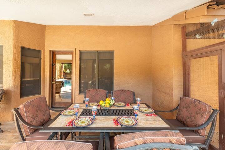 The outdoor dining table is conveniently positioned near the back door, ensuring effortless access to the kitchen.