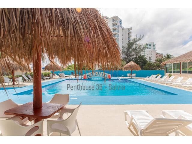 Pool features lounge chairs, palapas, and a small restaurant and bar onsite.