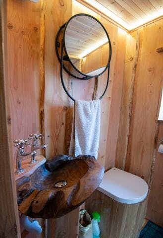 The en-suite bathroom has a wooden hand basin, compost loo, powerful shower and a large mirror which doubles as both shelving (behind the mirror) and a towel rail