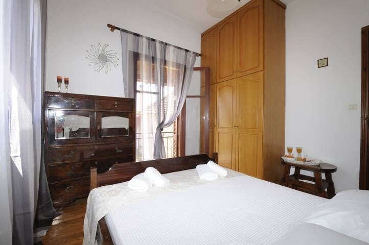 Comfortable double bed with a full size wardrobe and an antique walnut wood chest drawer. Balcony with views towards the village square with an ouzo table and chairs