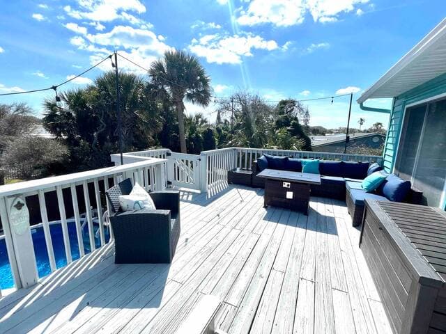 Comfortable outdoor deck has a gas grill and gas firepit coffee table.