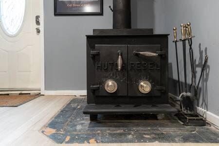 Living Room | Wood-Burning Stove Pictured is the mid-century wood-burning stove that makes the living room cozy. Plenty of firewood is available in the backyard to keep the warmth going.