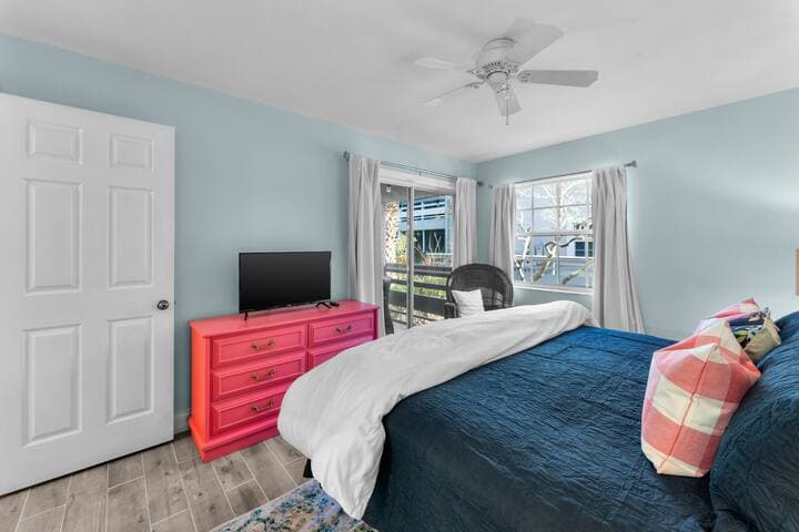 Primary bedroom facing sliders that lead to veranda (screened porch); smart TV