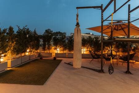 Shared rooftop gym on the 4th floor—(same umbrellas), open to all guests.
Your private garden waits just outside your suite downstairs.