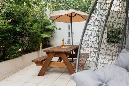 Your suite opens onto a private garden patio—it’s all yours. The rooftop terrace (same beige umbrellas, different level) is a shared space two floors up.