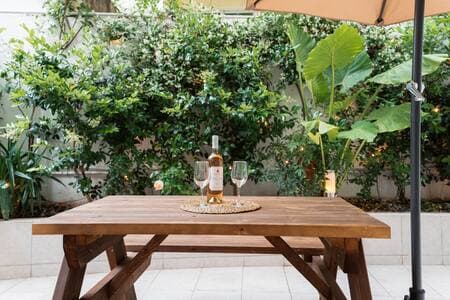 Your suite opens onto a private garden patio—it’s all yours. The rooftop terrace (same beige umbrellas, different level) is a shared space two floors up.