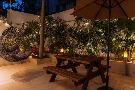 Your suite opens onto a private garden patio—it’s all yours. The rooftop terrace (same beige umbrellas, different level) is a shared space two floors up.