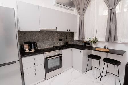 A kitchen with dining area, fully equipped with a large refrigerator and espresso machine – designed to meet all your daily needs for meals, drinks, and comfort.